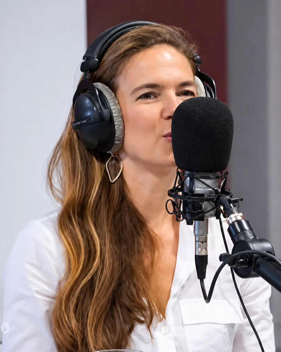 Simona Nicolaescu in the studio, headphones on, speaking into a microphone.